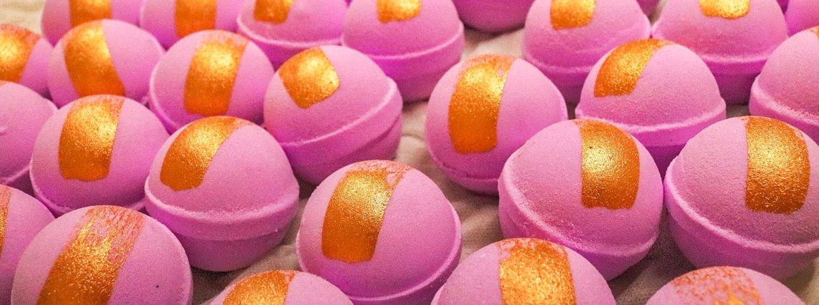 Lots of pink bath-bombs with a gold strip down the middle.