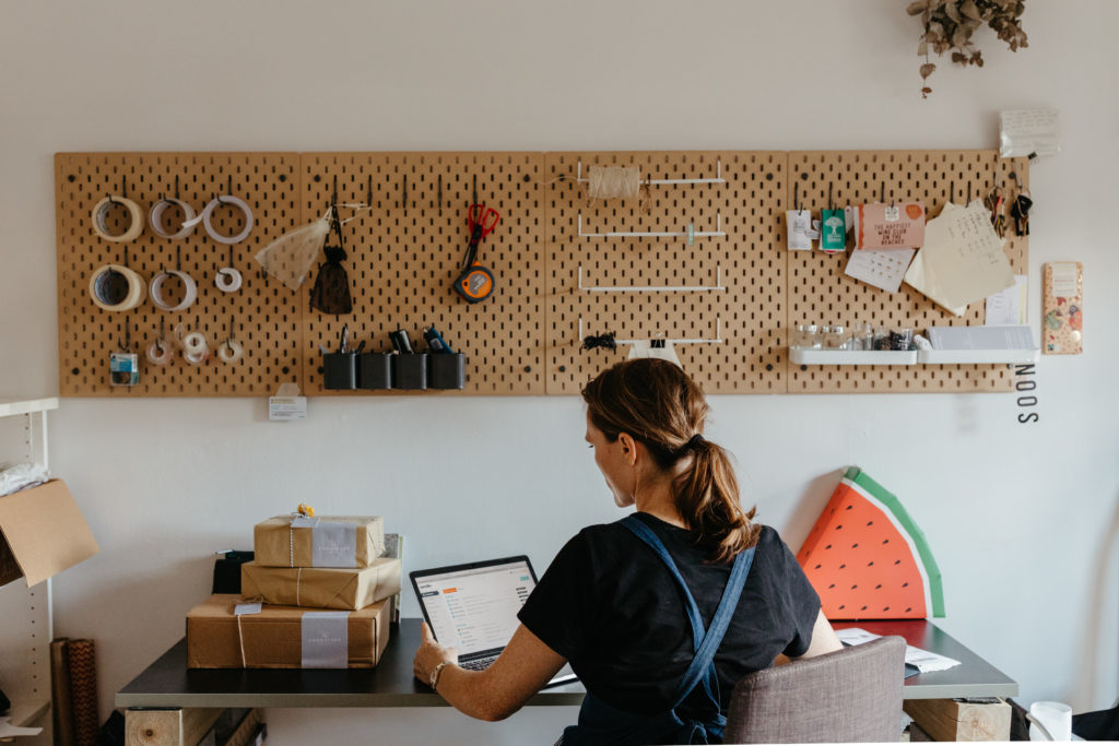 Woman with eco-friendly packaging at laptop.