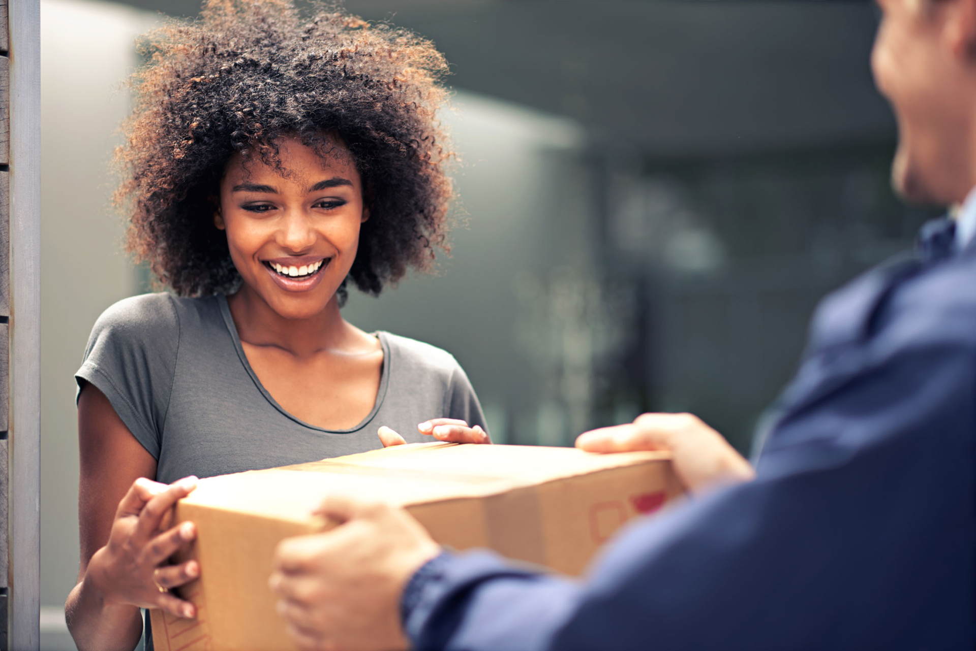 Woman receiving delivery box and smiling