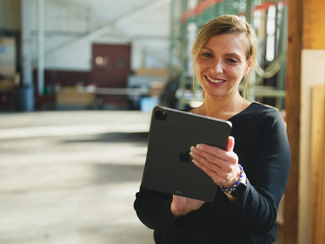 Smiling warehouse worker holding a tablet