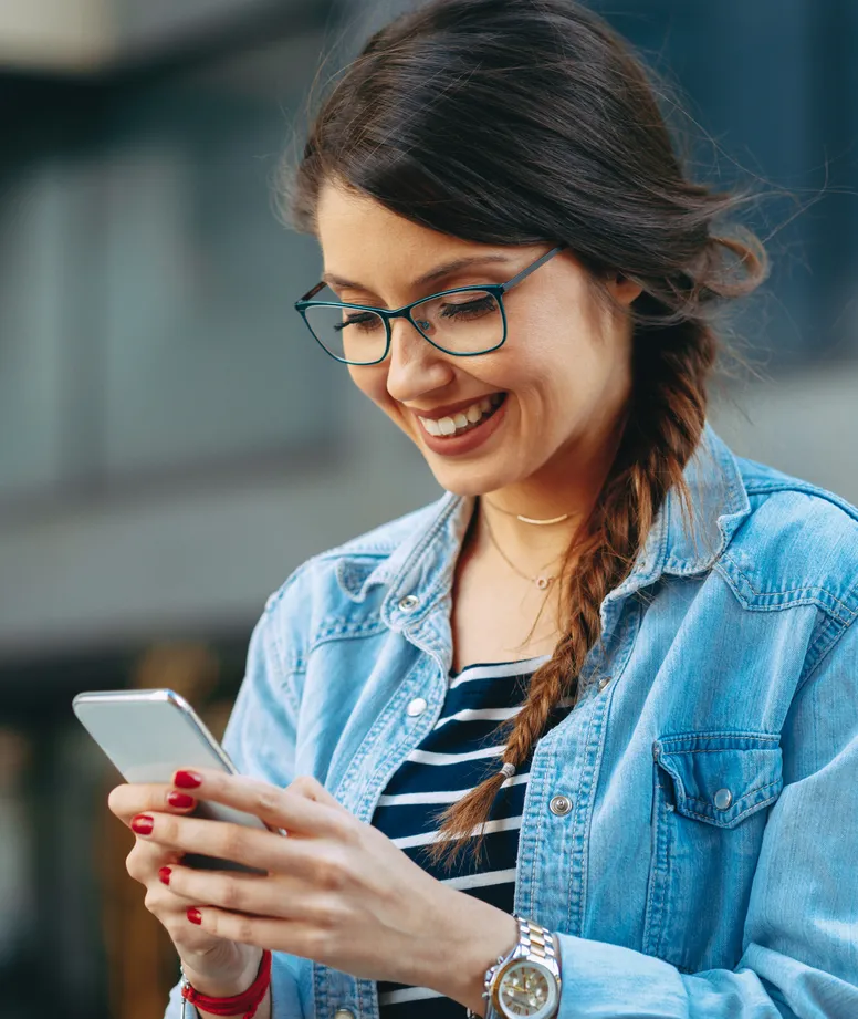 Smiling woman with glasses checking her phone